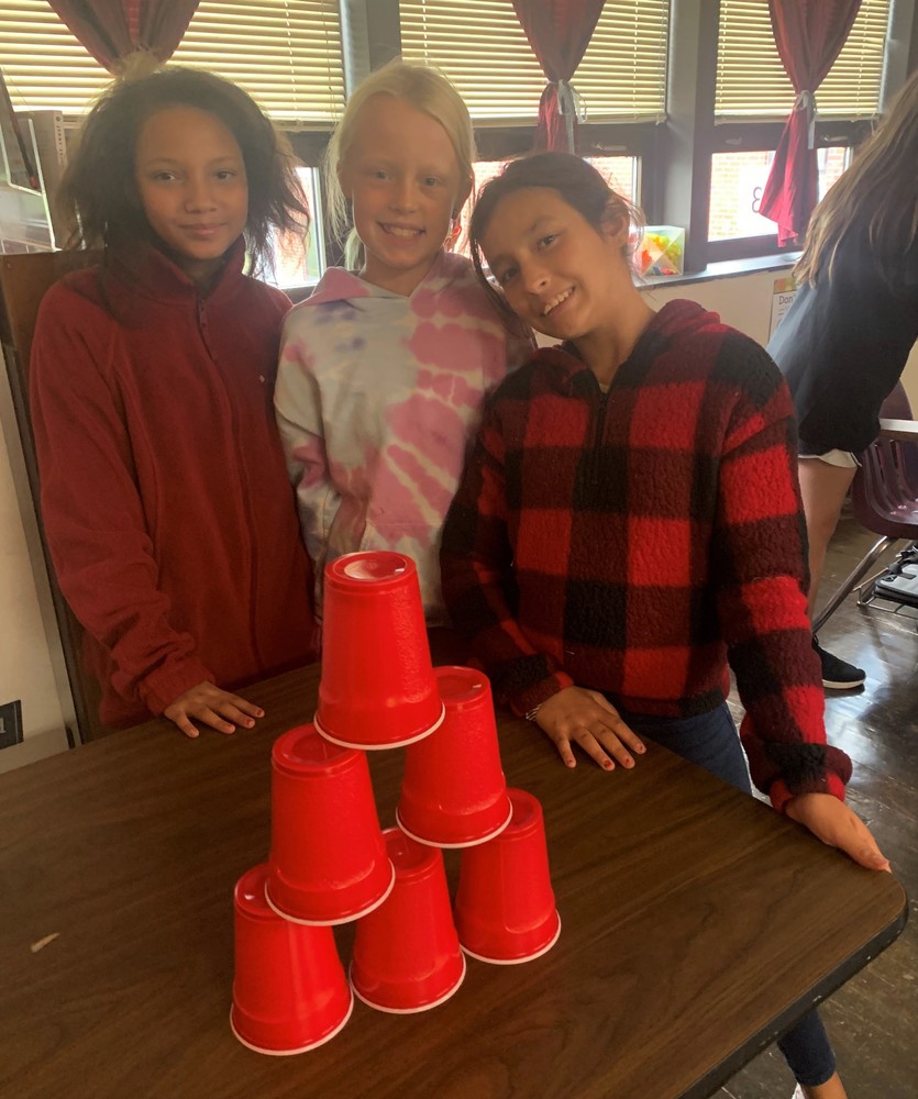 Students behind a stack of plastic cups 