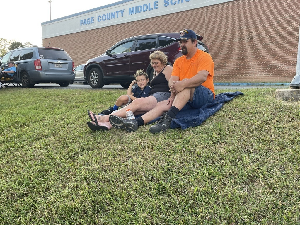 parents and child sitting on the grass